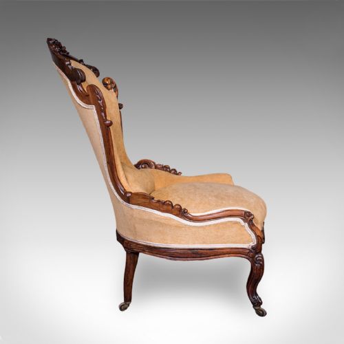 fig 4. An early Victorian carved mahogany salon armchair upholstered in gold velvet fabric accompanied by a matching small footstool.