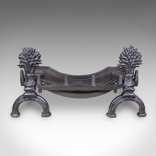fig 1. Victorian cast iron fire basket featuring curved grate bars and integrated front andirons decorated with wheat sheaf motifs.