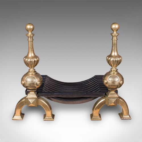 fig 1. A Victorian cast iron fire grate mounted between two tall brass firedogs featuring orb finials and splayed feet.