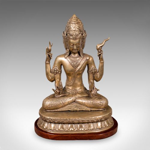 fig 1. An antique bronze multi-headed and four-armed Balinese deity figure seated in lotus position on a lotus base, mounted on an oval wooden plinth.