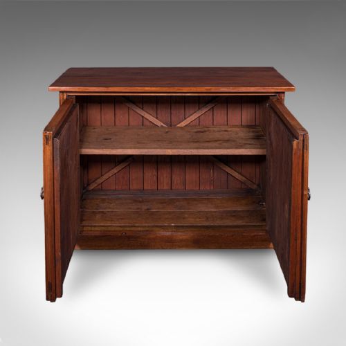 fig 2. A low Victorian Gothic Revival wooden cabinet with double doors featuring carved pointed arches, geometric panelling, and twin metal drop handles.