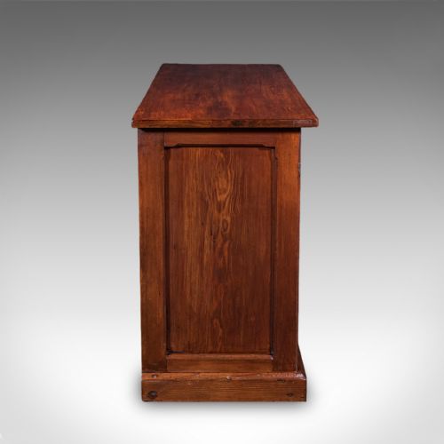 fig 3. A low Victorian Gothic Revival wooden cabinet with double doors featuring carved pointed arches, geometric panelling, and twin metal drop handles.