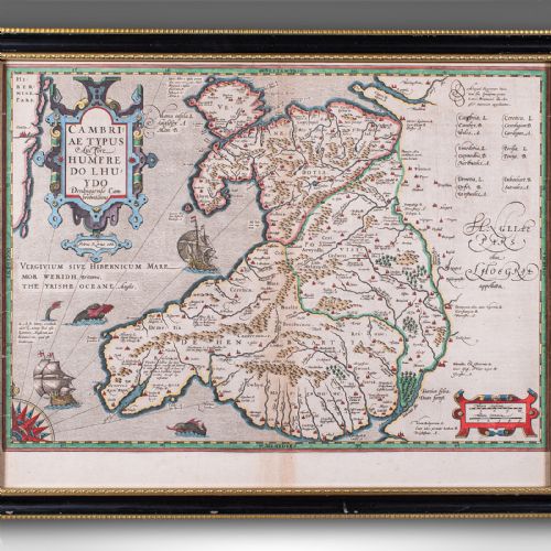 fig 3. A framed antique hand-coloured map of Wales featuring decorative cartouches, sea vessels, and an ebonised frame with a gilded inner moulding.