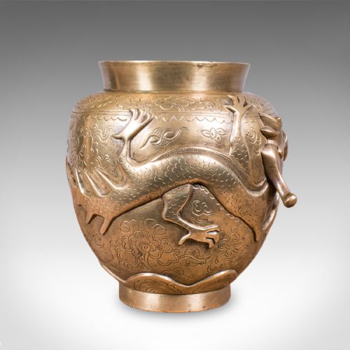 fig 2. A cast bronze urn featuring a raised dragon motif encircling the body over a chased decorative background.