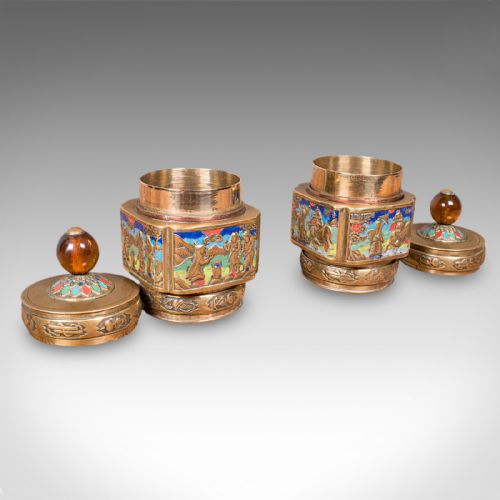 fig 1. A pair of Edwardian brass tea caddies featuring polychrome champleve enamel figurative panels and amber-coloured spherical finials.
