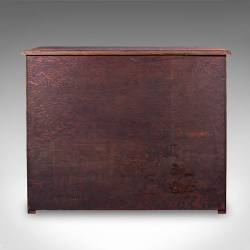 fig 4. An antique Edwardian medium brown oak sideboard featuring three upper drawers with brass drop handles above panelled cupboard doors.