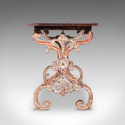 fig 2. A Victorian table featuring an ornate white distressed cast iron scrollwork base and a smooth mahogany top.