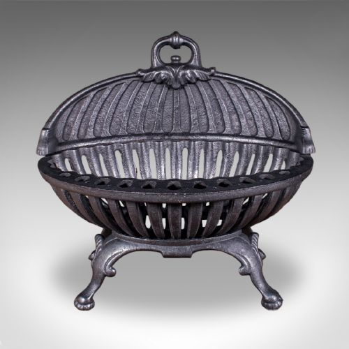fig 1. A charcoal black cast iron fire basket featuring a fluted domed backplate, curved front grate, and scrolled feet.