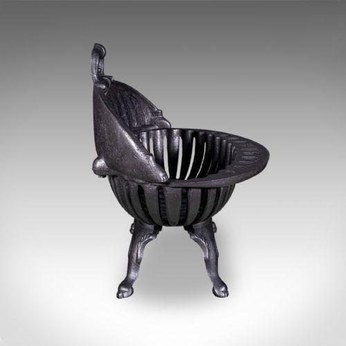 fig 2. A charcoal black cast iron fire basket featuring a fluted domed backplate, curved front grate, and scrolled feet.