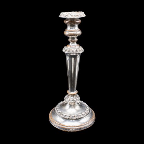 fig 2. A pair of Regency period Old Sheffield plate silver candlesticks featuring tapered columns, gadrooned borders, and circular bases with copper undertones.