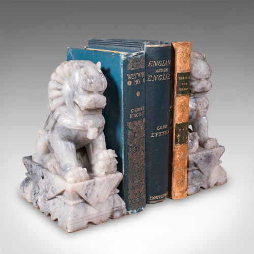 fig 1. A pair of hand-carved mottled grey soapstone guardian lion bookends mounted on carved pedestals.