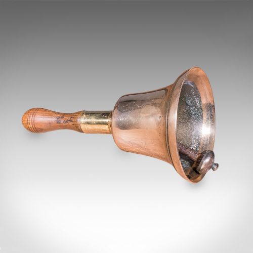 fig 2. Victorian hand bell featuring a polished brass bell body with a turned beech handle set on a circular wooden stand.