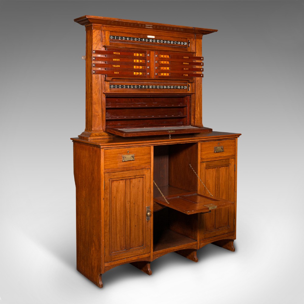 An Edwardian English walnut billiard score cabinet featuring built-in life pool scorers, ball storage racks, brass handles, drawers, and lower cupboard space.