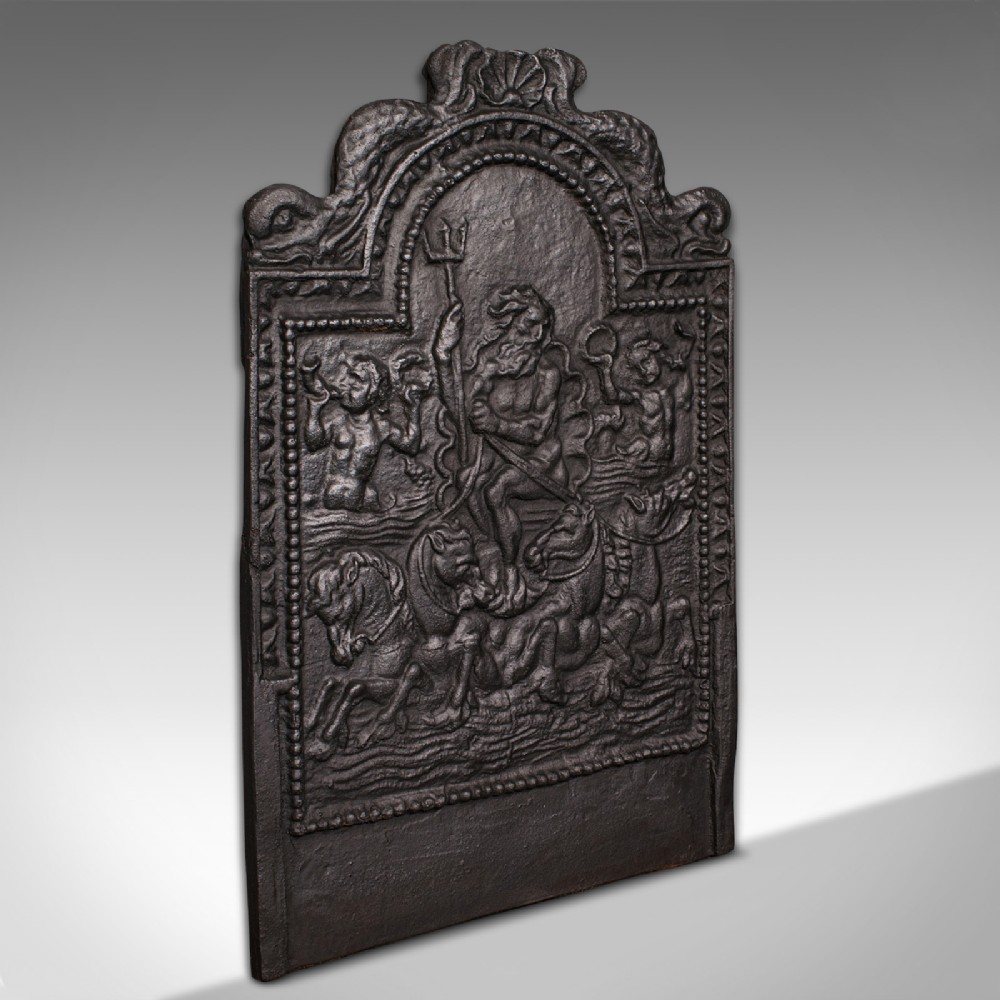 A heavy late Victorian cast iron fireback depicting a relief scene of Neptune holding a trident on a chariot drawn by sea horses.