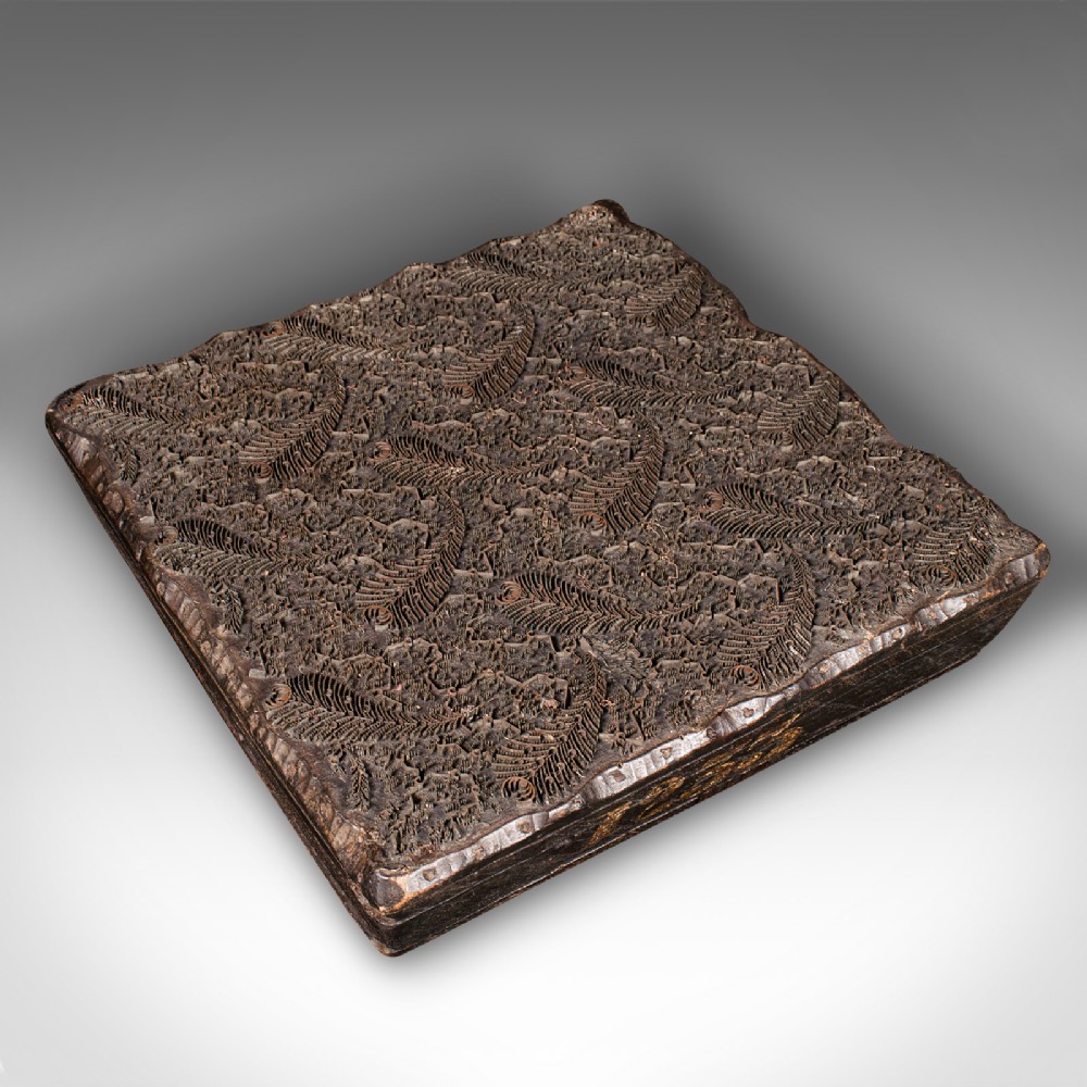 A square dark hardwood textile printing block featuring intricate inlaid metal foliage and fern patterns.