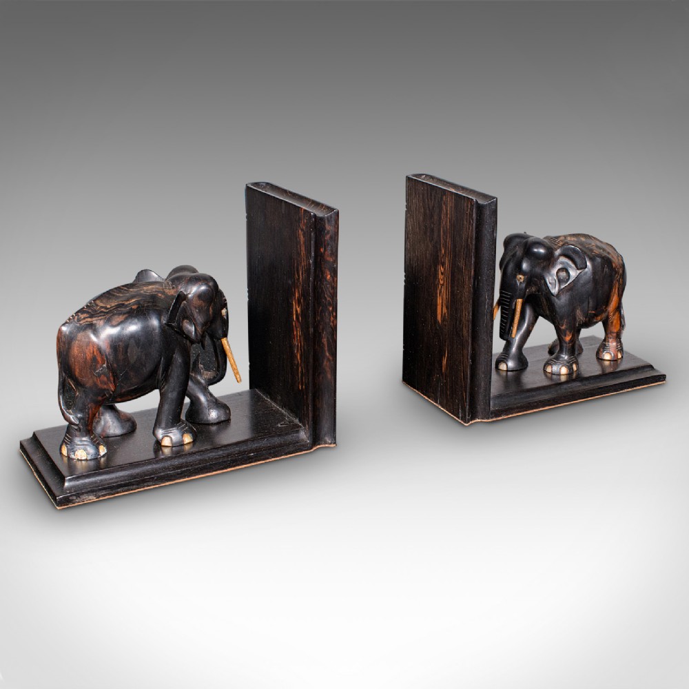Pair of Victorian Anglo-Indian coromandel wood bookends featuring carved elephant figures with bone tusks on L-shaped bases.