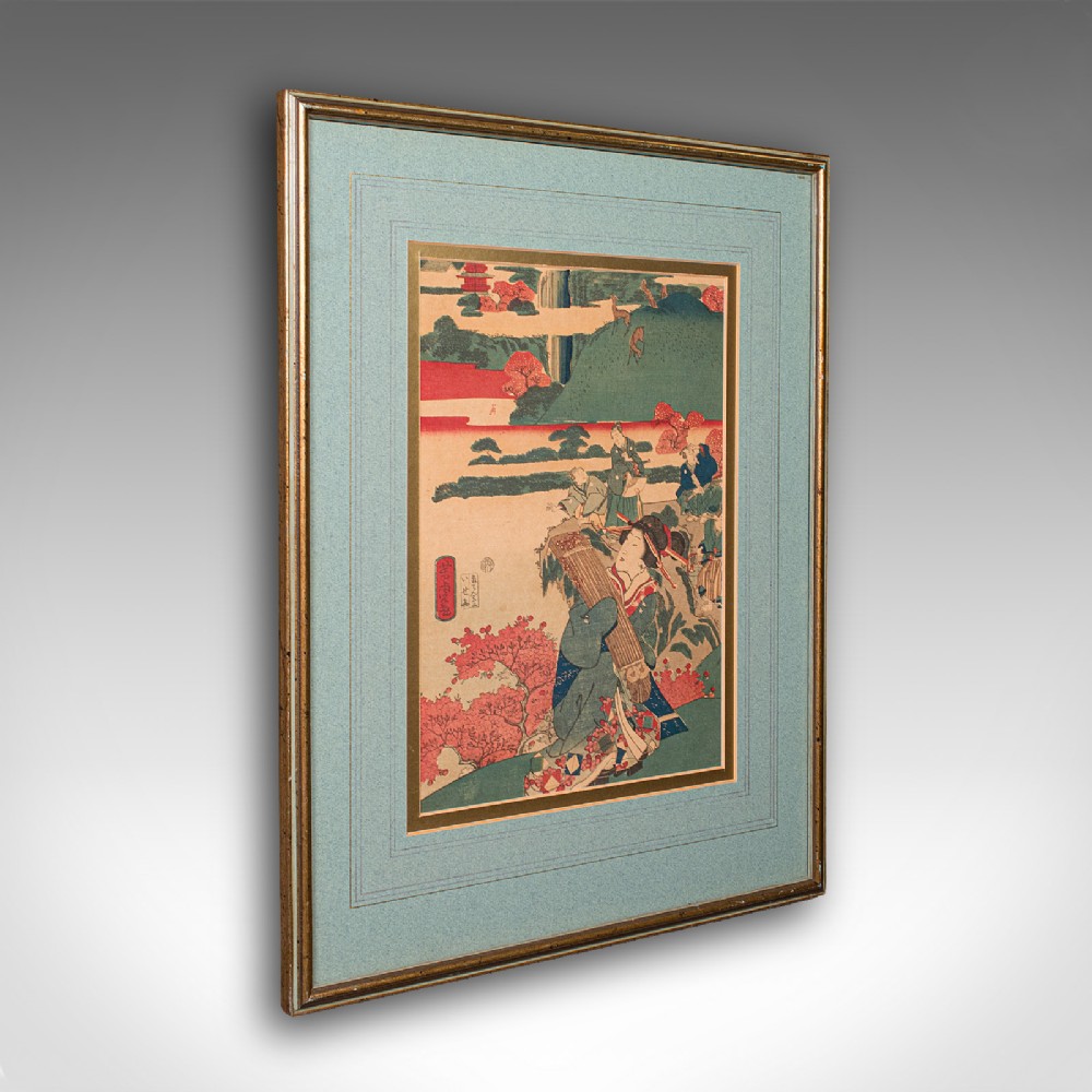 An antique Japanese ukiyo-e woodblock print set within a double mount and a gilt wooden frame.