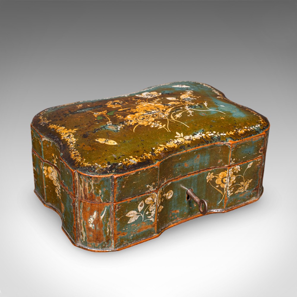 An antique serpentine-shaped green lacquered table box decorated with hand-painted yellow flowers and fitted with an iron key in the front lock.