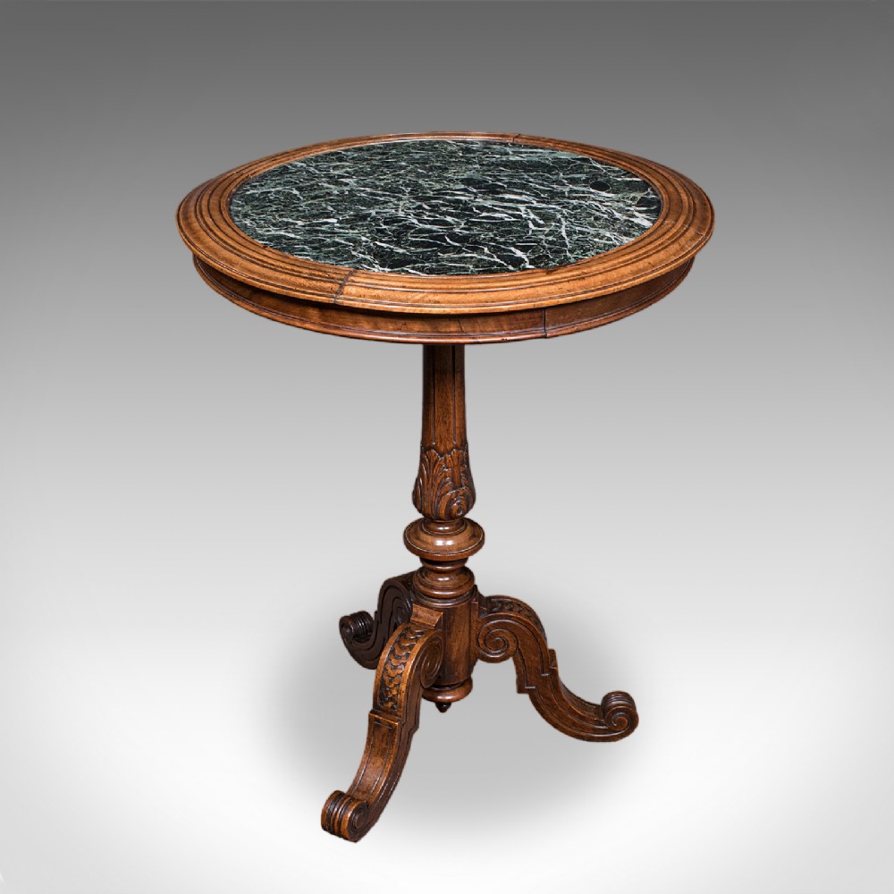 A High Victorian walnut wine table with a circular green marble inset top set on a carved tripod pedestal base.
