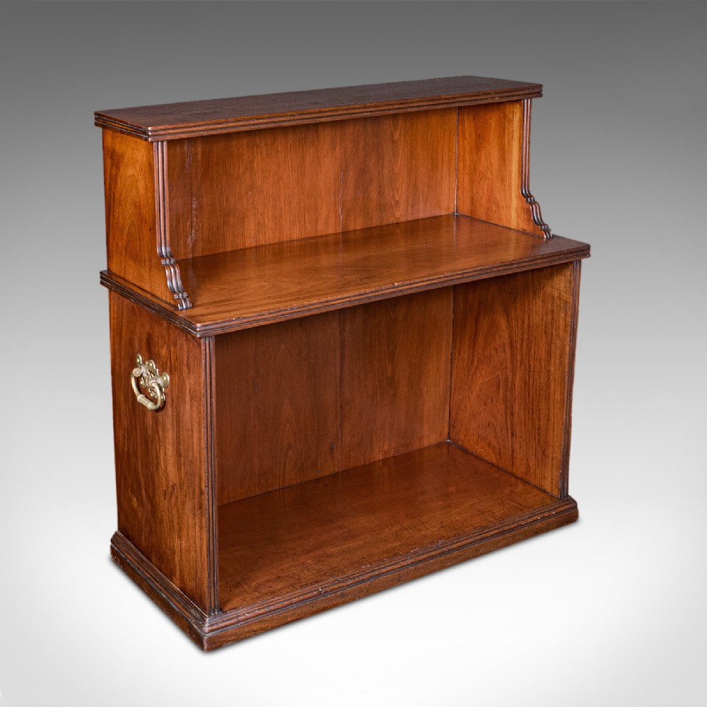 A Victorian mahogany two-tier open campaign folio bookcase featuring brass side carrying handles and a stepped upper shelf.
