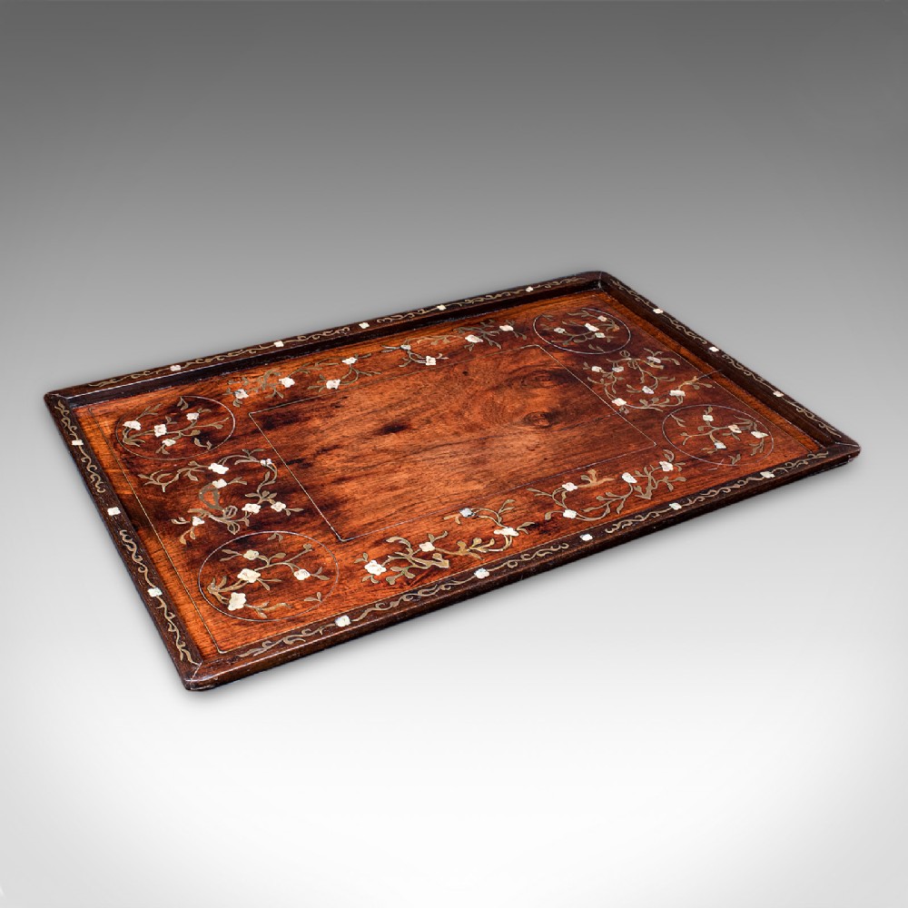 A rectangular dark brown teak wood tray featuring intricate floral bone and brass wire inlay around the borders.