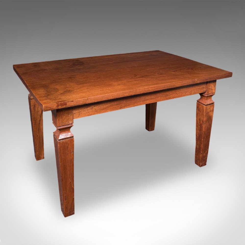 An Edwardian rectangular English walnut dining table featuring tapered legs with carved collars and a smooth polished top.
