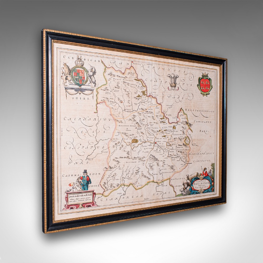 A framed 17th-century map of Breconshire featuring hand-coloured coats of arms and a black and gold decorative frame.