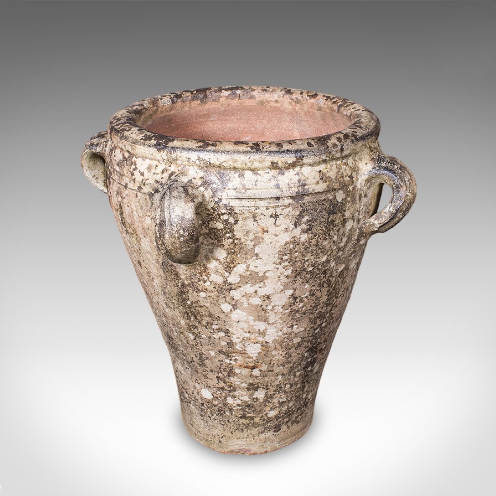 A tapered antique Tuscan terracotta planter featuring four side lug handles and a heavily weathered grey lichen patina.