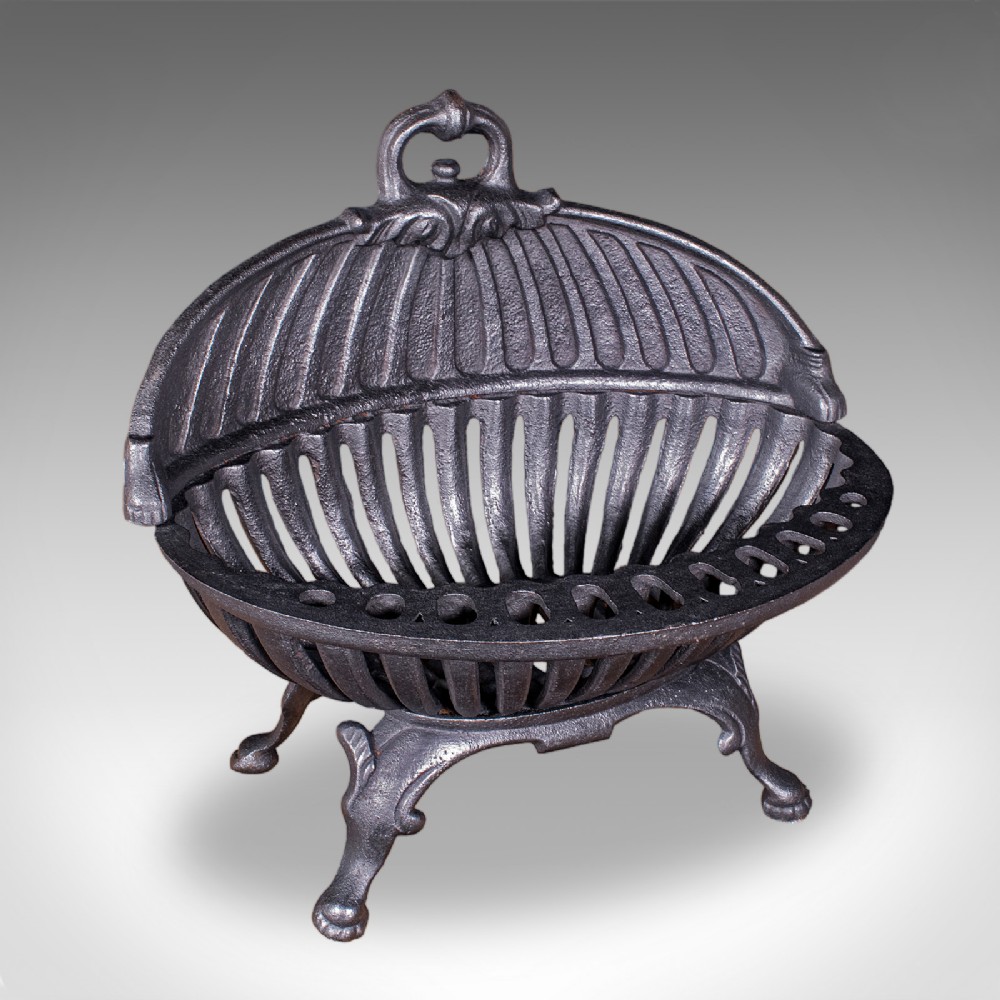 A charcoal black cast iron fire basket featuring a fluted domed backplate, curved front grate, and scrolled feet.