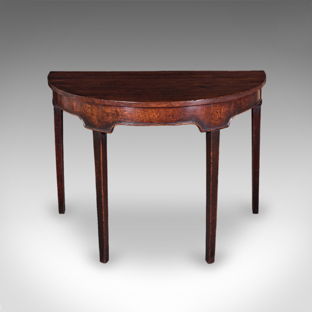 An antique dark mahogany demi-lune console table featuring tapered legs and a curved frieze. View II