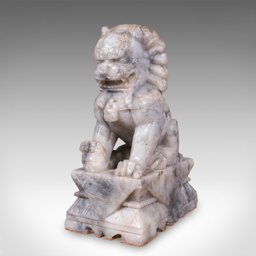 A pair of hand-carved mottled grey soapstone guardian lion bookends mounted on carved pedestals. View VIII