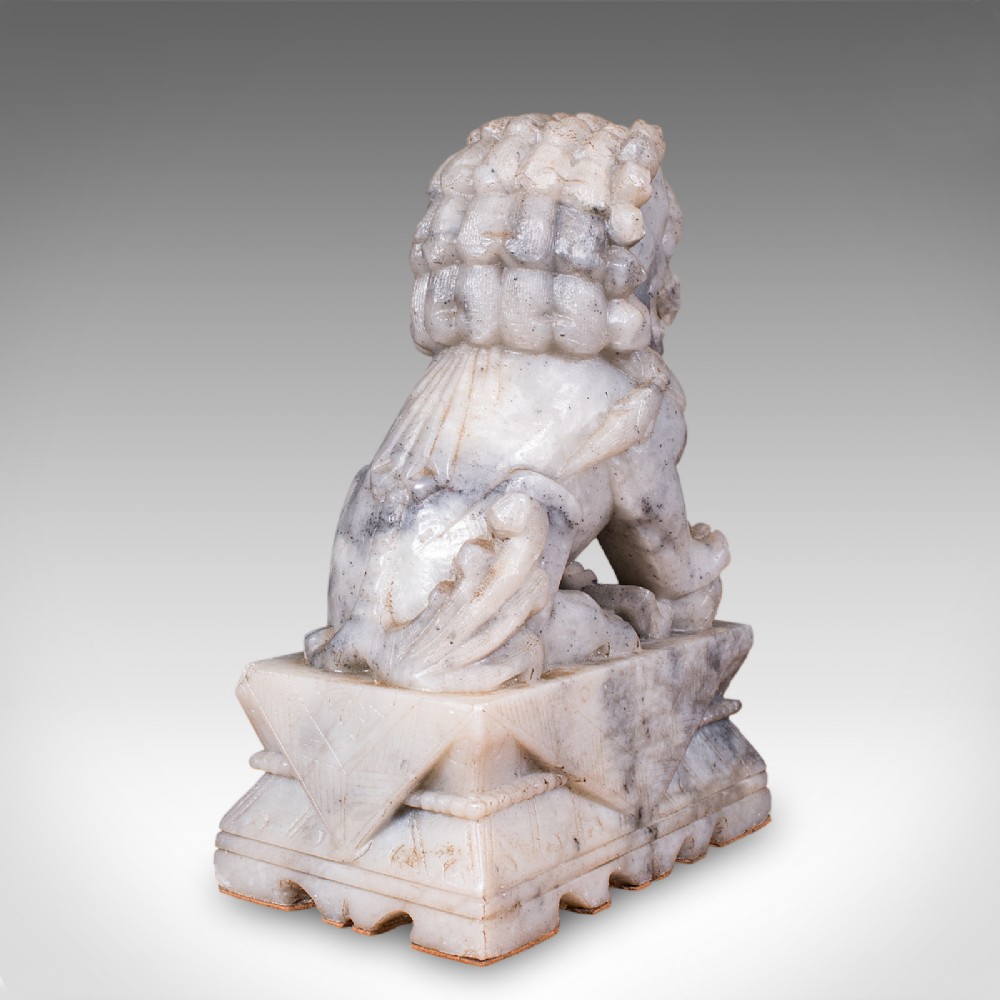 A pair of hand-carved mottled grey soapstone guardian lion bookends mounted on carved pedestals. View IX