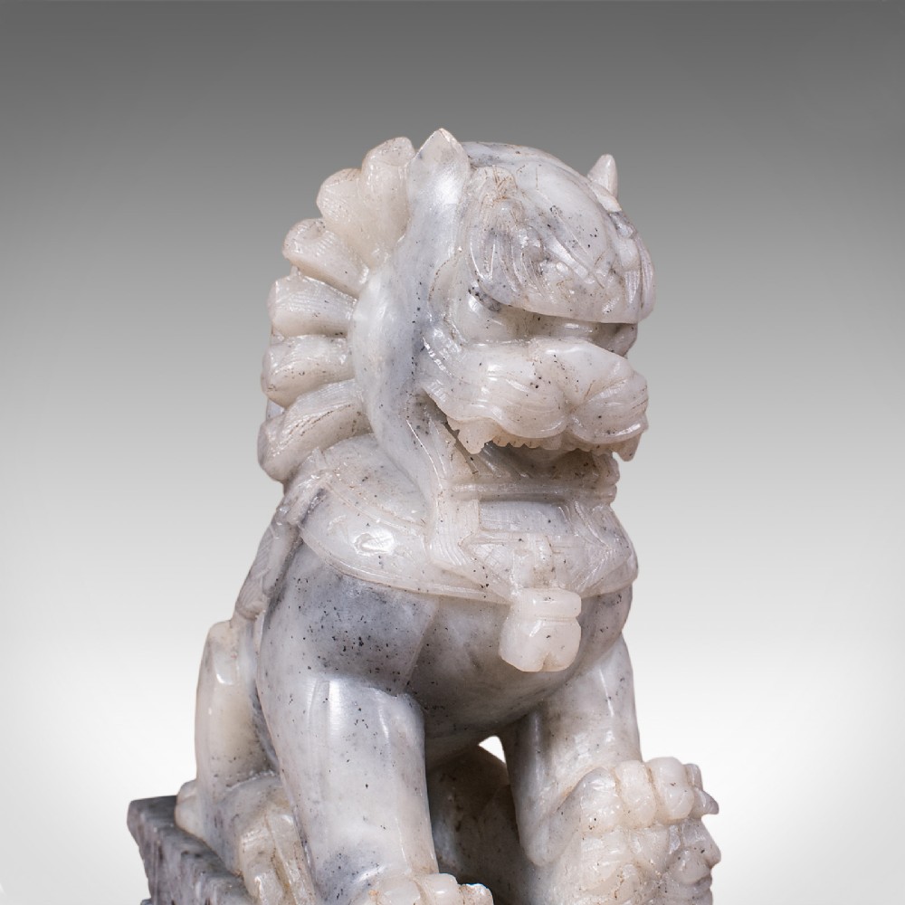 A pair of hand-carved mottled grey soapstone guardian lion bookends mounted on carved pedestals. View X