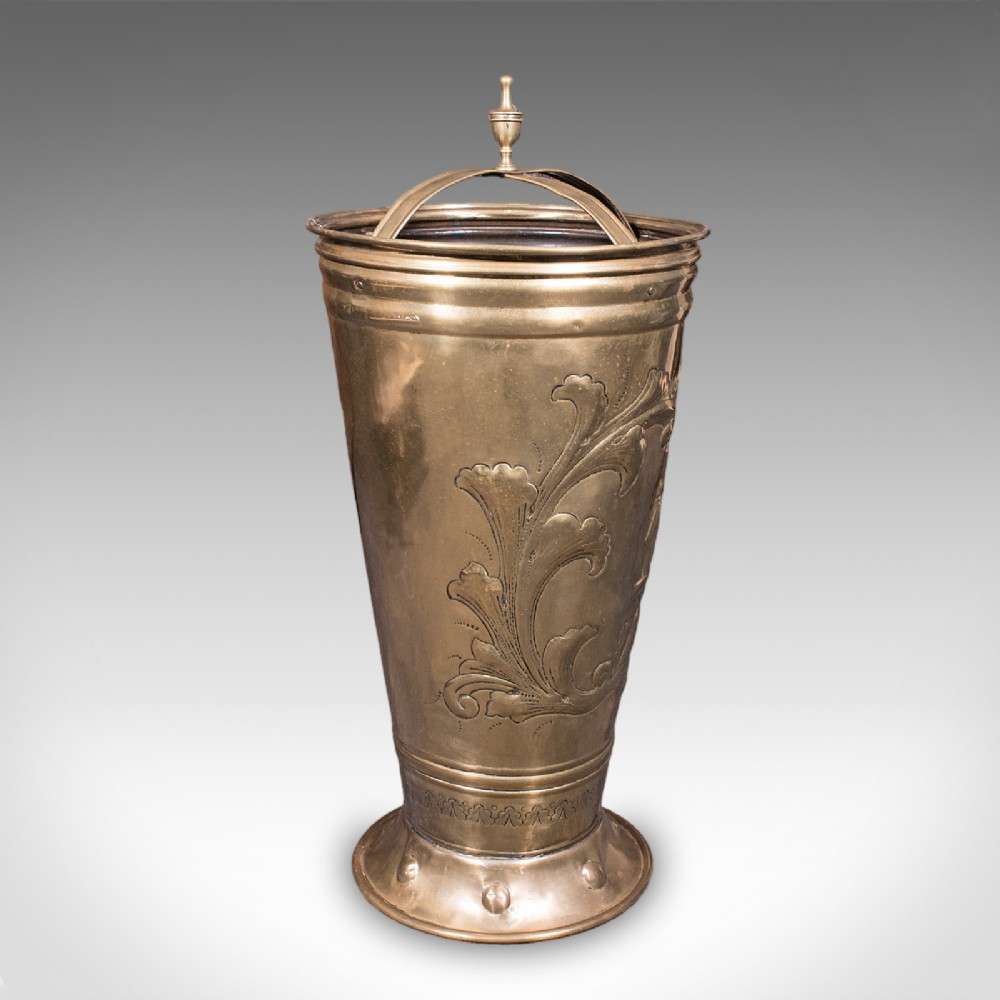 An antique tapered brass umbrella stand featuring embossed Dutch windmill motifs, top dividers with a turned brass finial, and a flared base. View III