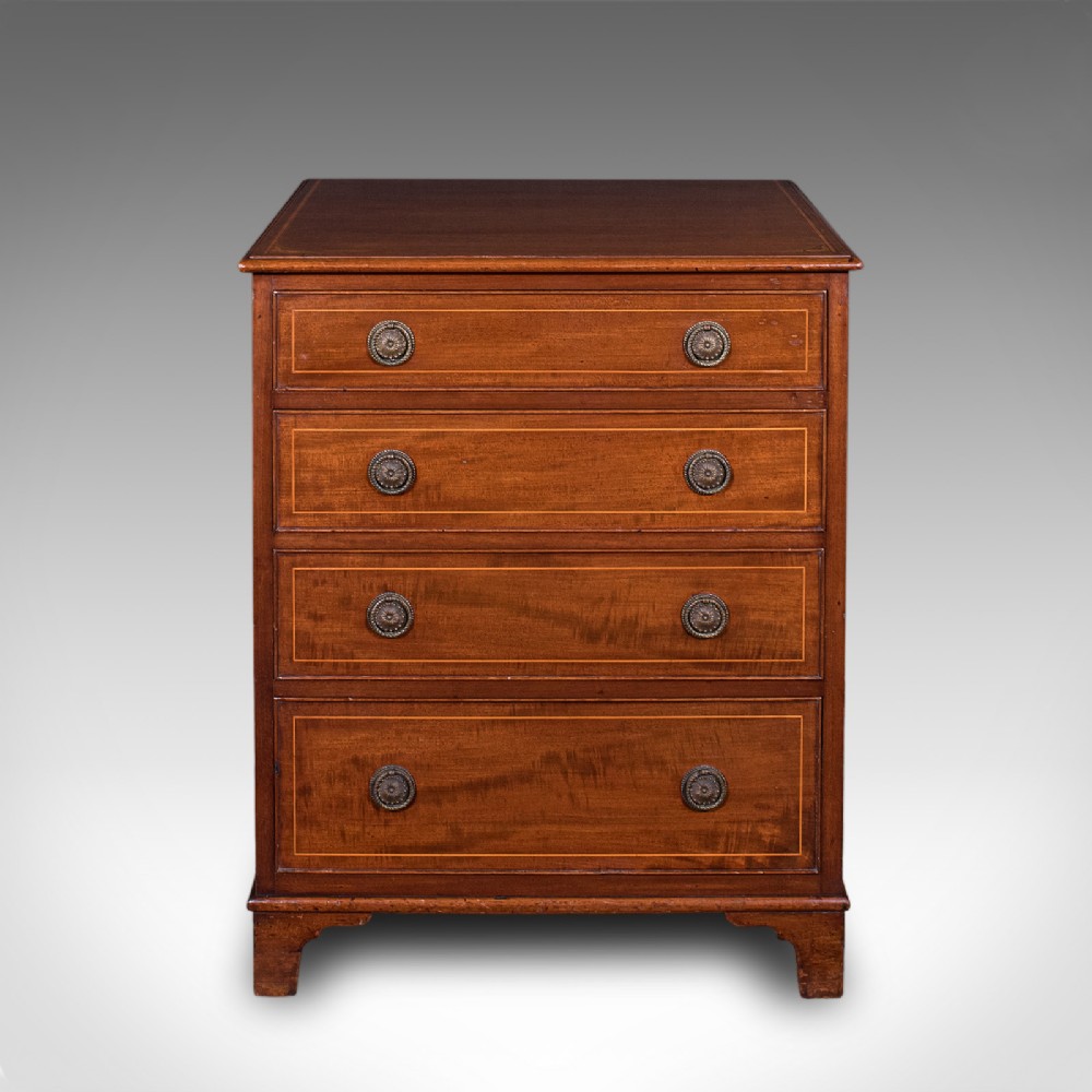 An antique mahogany small chest of drawers featuring four graduated inlaid drawers, circular brass ring pull handles, and bracket feet. View III