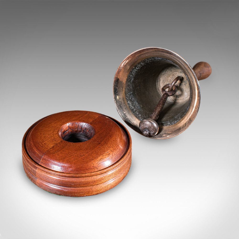Victorian hand bell featuring a polished brass bell body with a turned beech handle set on a circular wooden stand. View II