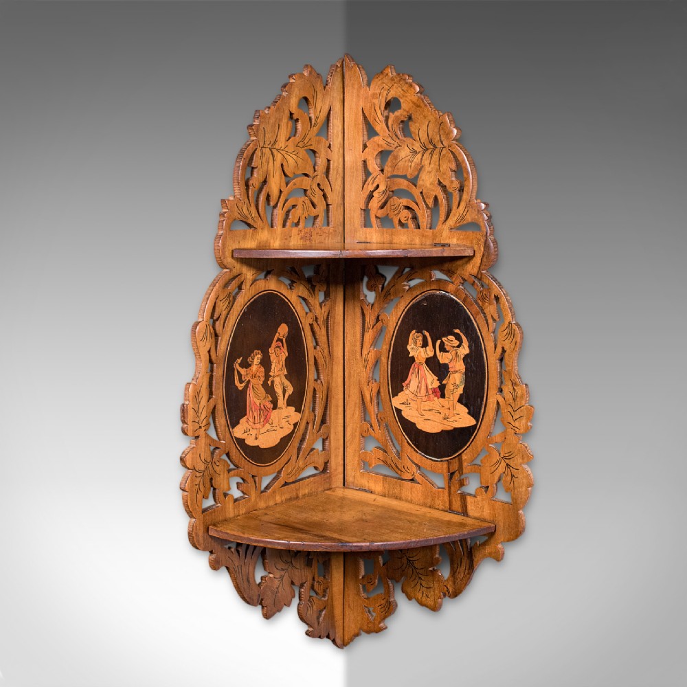 A Victorian Italian walnut corner display shelf featuring two tiers, openwork foliage fretwork borders, and oval marquetry panels depicting folk dancers. View II