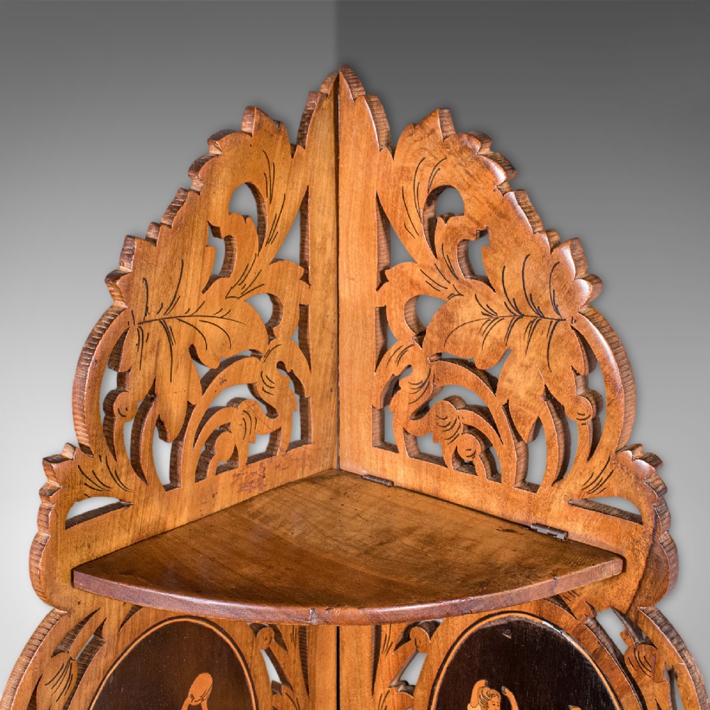 A Victorian Italian walnut corner display shelf featuring two tiers, openwork foliage fretwork borders, and oval marquetry panels depicting folk dancers. View V