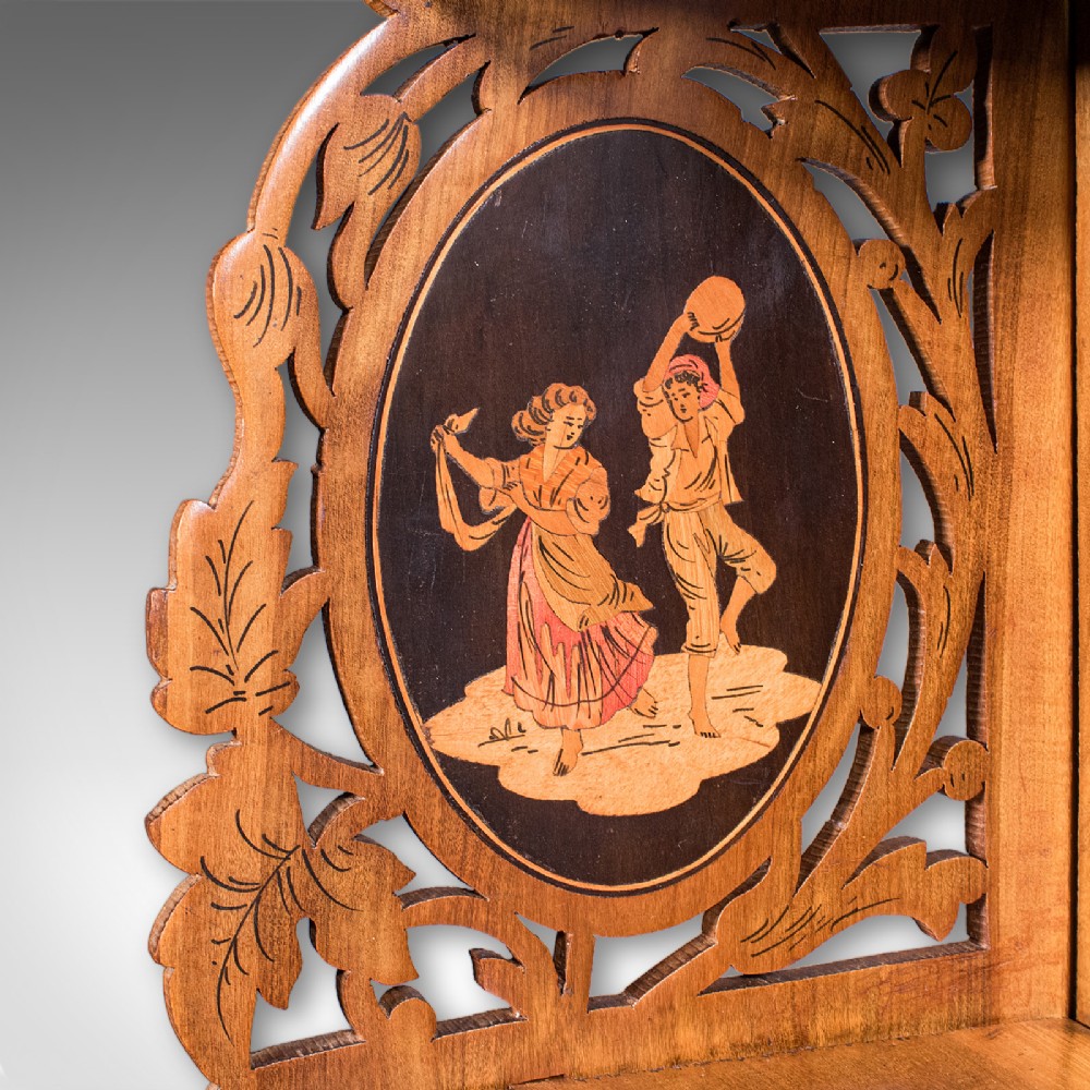 A Victorian Italian walnut corner display shelf featuring two tiers, openwork foliage fretwork borders, and oval marquetry panels depicting folk dancers. View VII