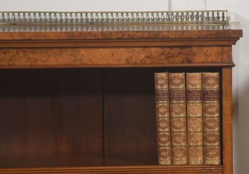 fig 1. A pair of low burr walnut open bookcases featuring brass galleries along the top and adjustable interior shelves.