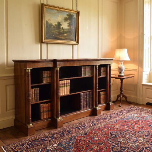 fig 1. A Regency period open breakfront bookcase crafted from dark rosewood with brass mounted column pilasters and adjustable shelves.