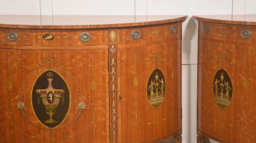 fig 2. A pair of golden satinwood demi-lune cabinets featuring central hand-painted oval urn motifs and tapered legs.