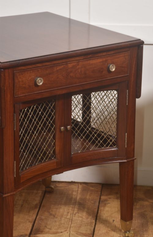 fig 1. A pair of rosewood drop-leaf side tables featuring single drawers above cupboard doors with brass grille inserts, standing on square tapered legs with brass castors.