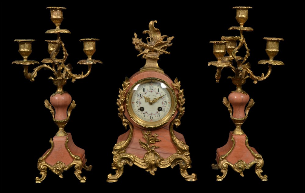 French three piece pink marble and gilt metal clock set