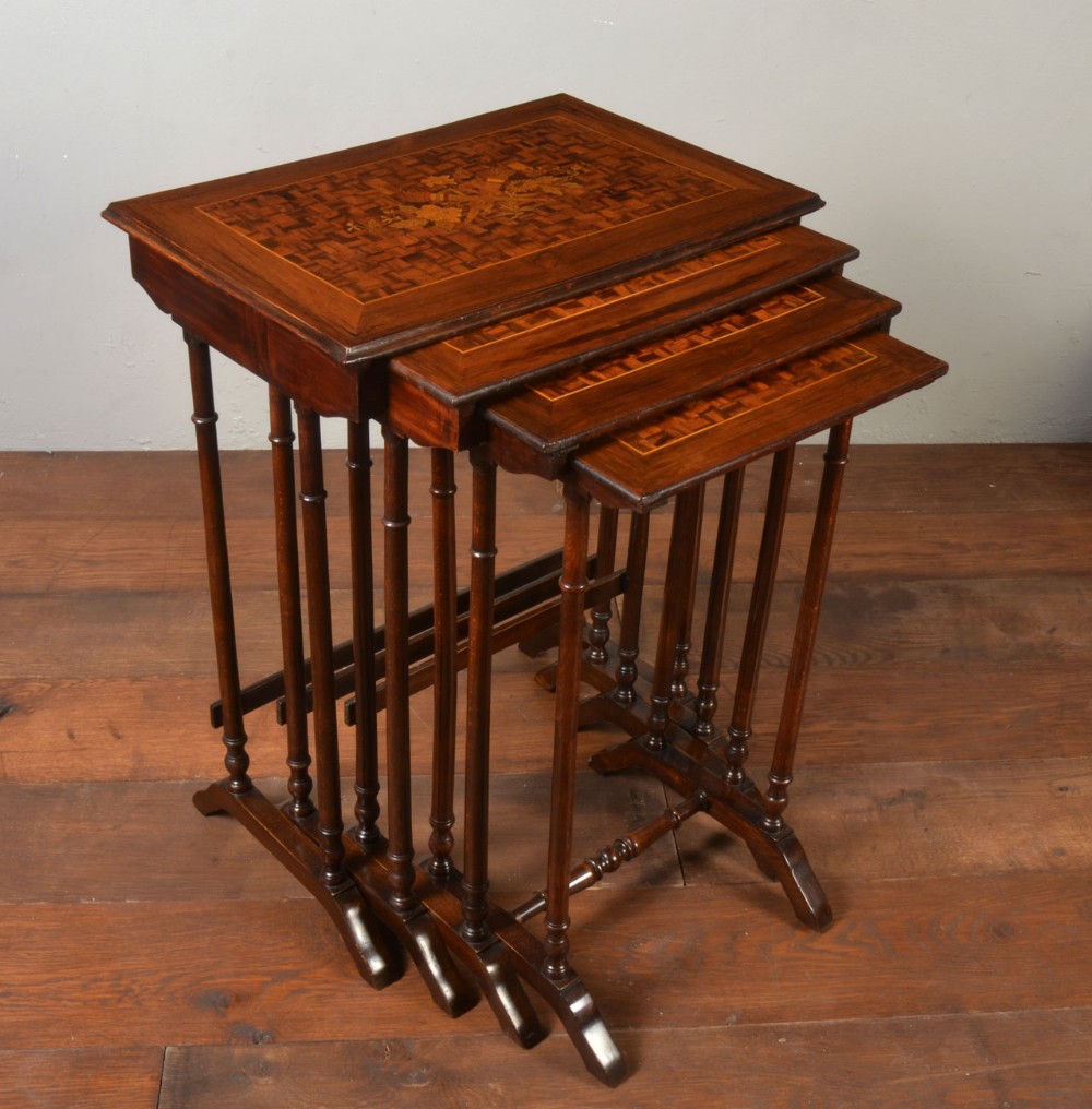 Nest of four walnut parquetry topped tables 