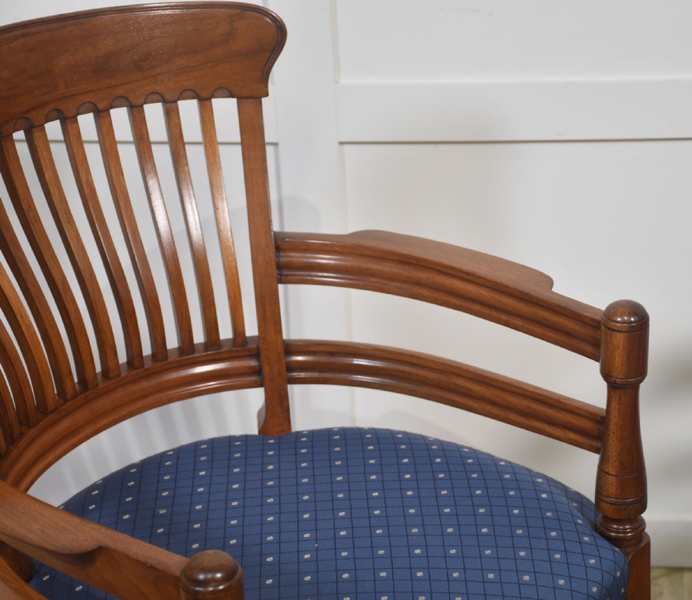 A pair of mahogany elbow chairs featuring slatted curved backs, turned front legs, and blue patterned upholstered seats. View VII