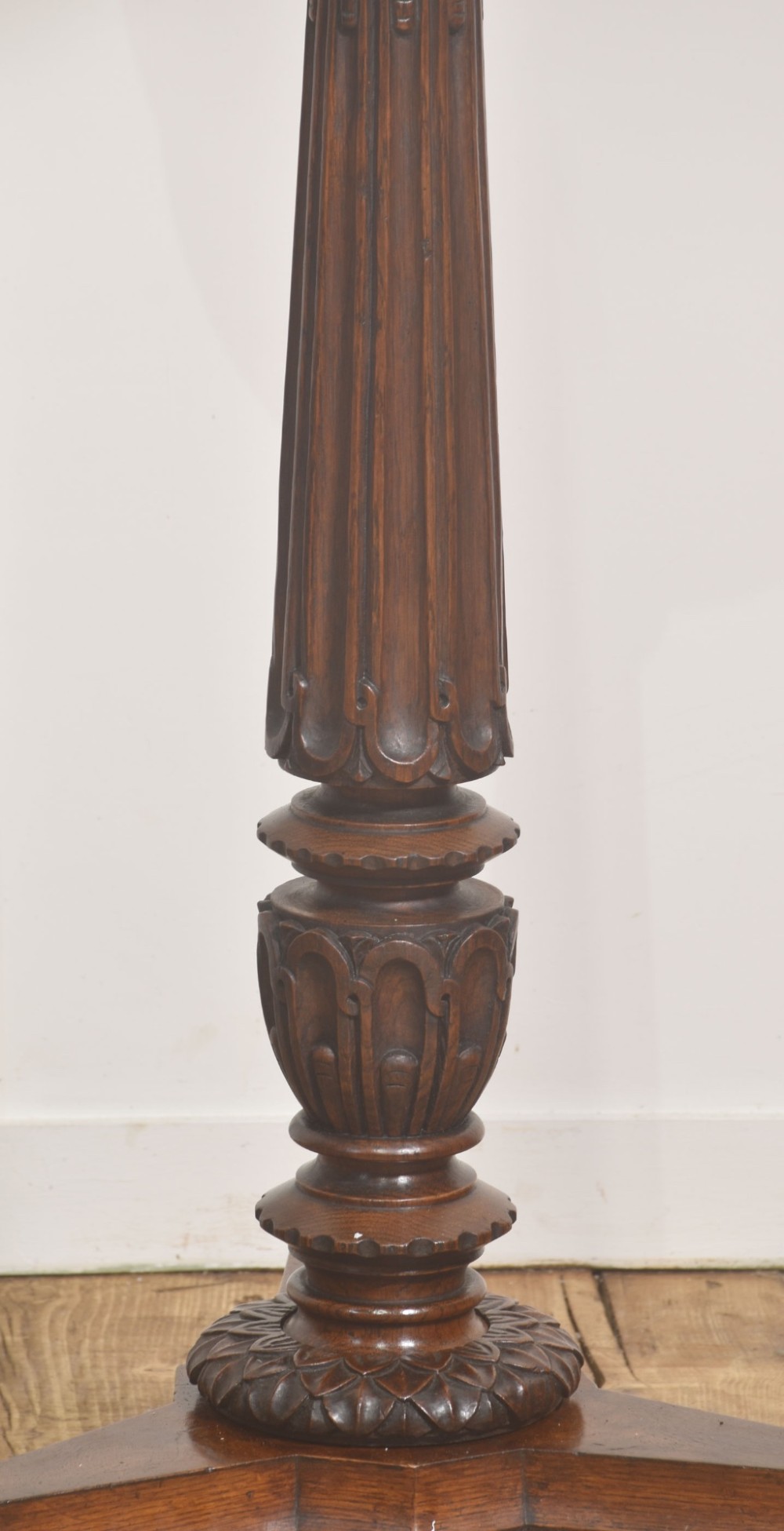 A 19th-century carved oak plant stand featuring a circular dish top, fluted central column, and a tripod base with carved scroll feet. View II