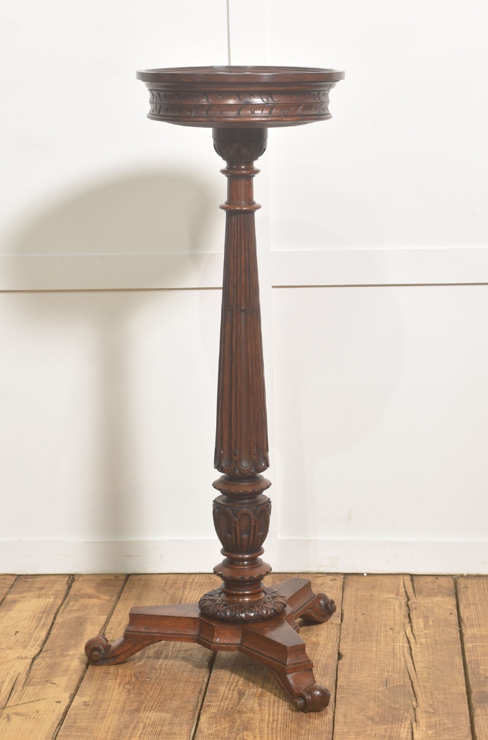 A 19th-century carved oak plant stand featuring a circular dish top, fluted central column, and a tripod base with carved scroll feet. View V