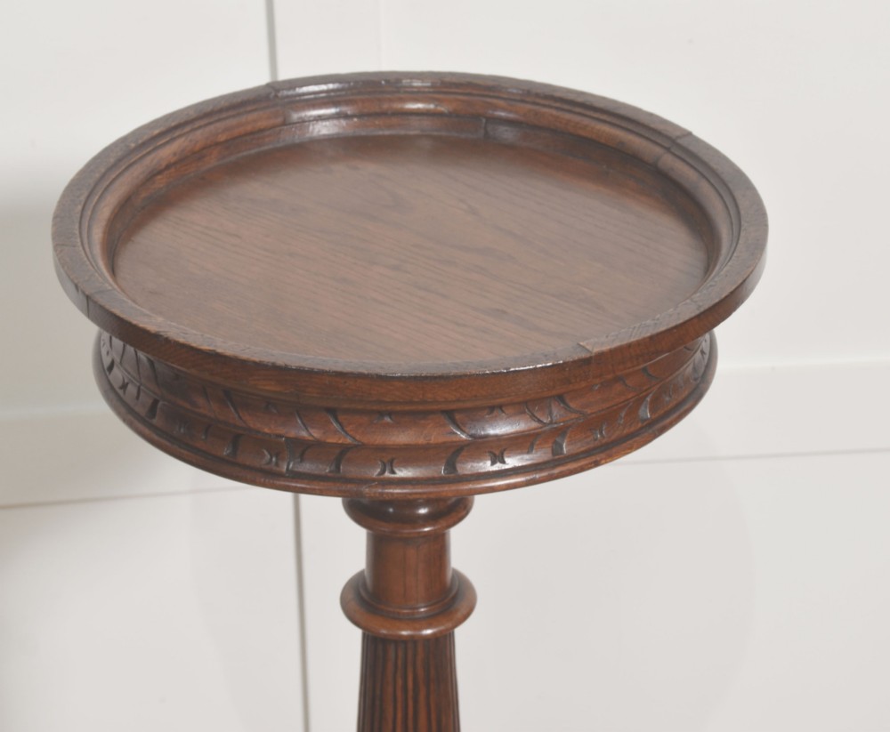 A 19th-century carved oak plant stand featuring a circular dish top, fluted central column, and a tripod base with carved scroll feet. View VI
