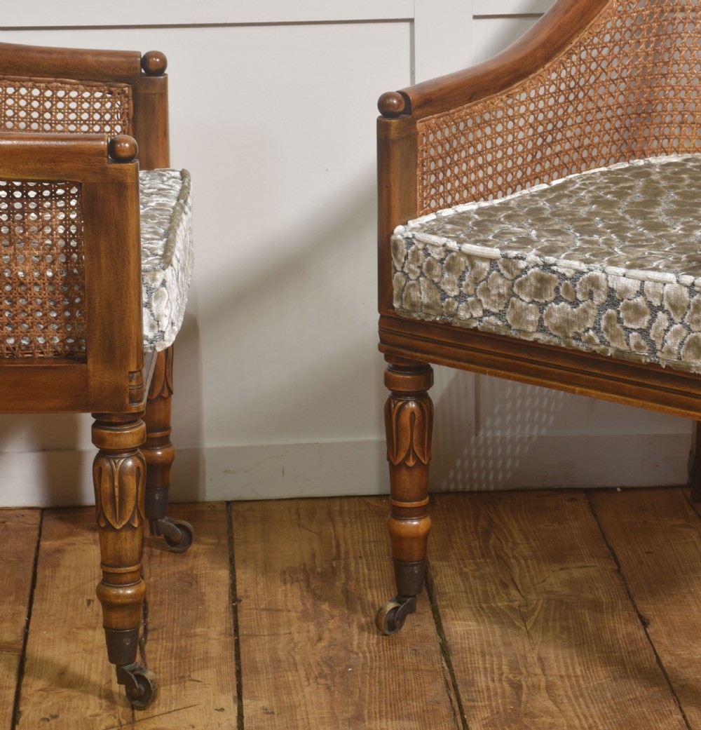 Pair of Regency style mahogany tub chairs featuring woven cane backs, upholstered cushions, turned legs, and brass castors. View V